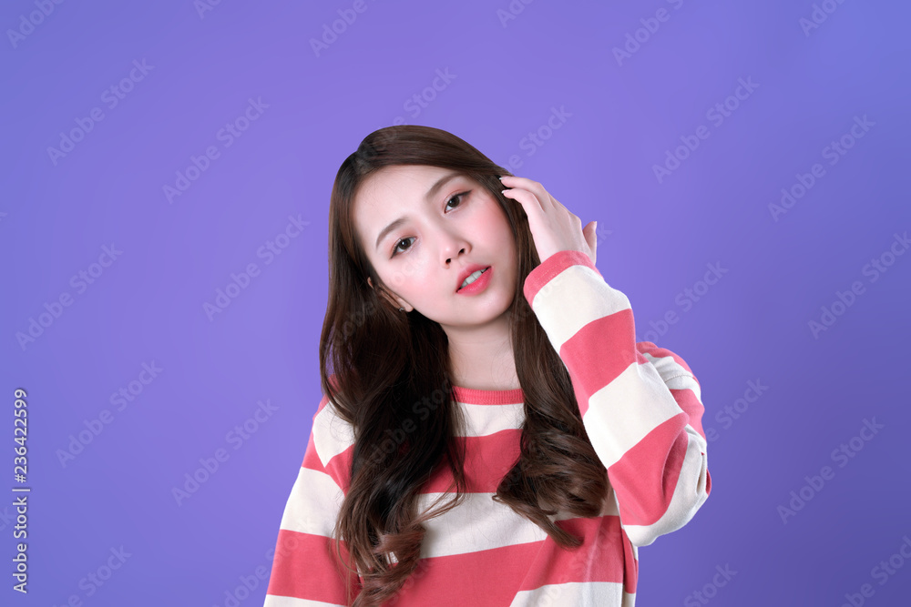 Long hair Korean woman looking and touch her hair, winter t-shirt clothing, purple background Long hair Korean woman looking and touch her hair, winter t-shirt clothing, purple background