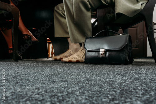 Legs and briefcase in office