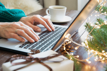 Christmas sales. Woman typing on laptop in home interior. Xmas concept. Planing holidays. Web search.