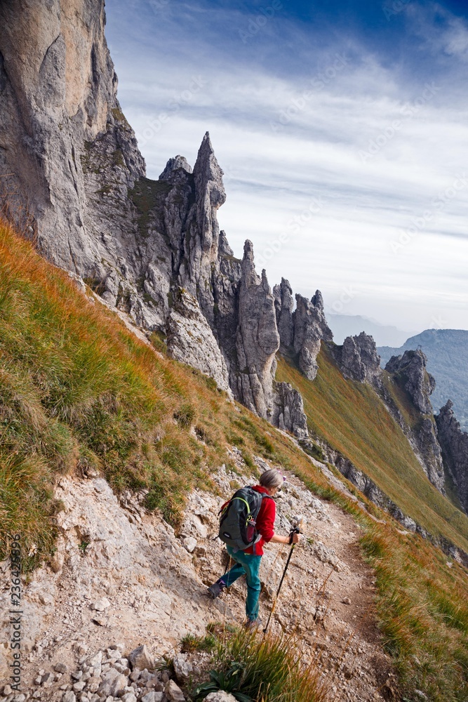 A woman hiker, descends from a steep trail of the Southern Grigna.