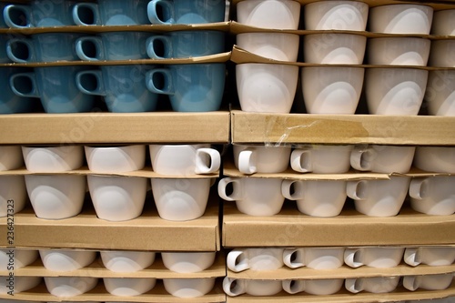 Stack of white and blue cups with cardbord boxes between