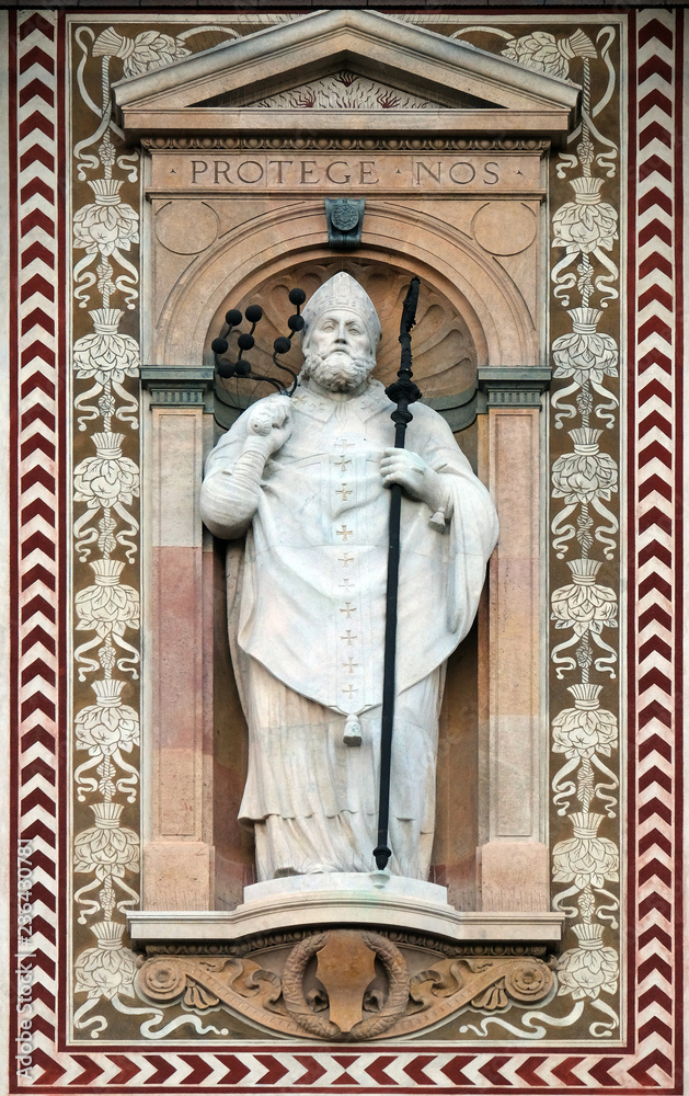 Statue of Sant'Ambrogio (Saint Ambrose) patron of the city of Milano (Milan). Detail of the clock tower of the Sforza Castle XV century (Castello Sforzesco). Lombardy, Italy