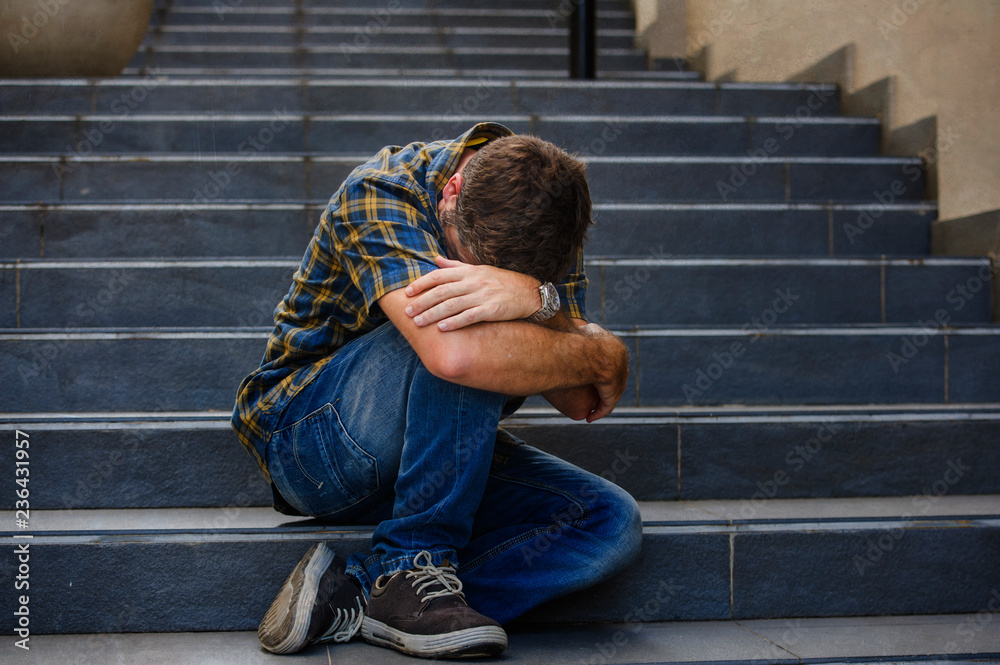 young sad and desperate man sitting outdoors at street stairs suffering anxiety and depression feeling miserable crying in unemployment and broken heart concept young sad and desperate man sitting outdoors at street stairs suffering anxiety and depression feeling miserable crying in unemployment and broken heart concept