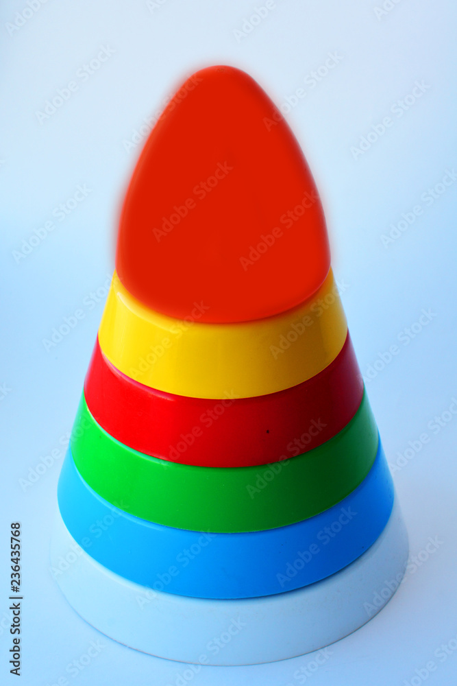 Children's toy pyramid from multi colored circles on a white background