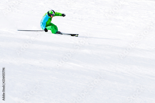 skier in a green suit on a snowy slope