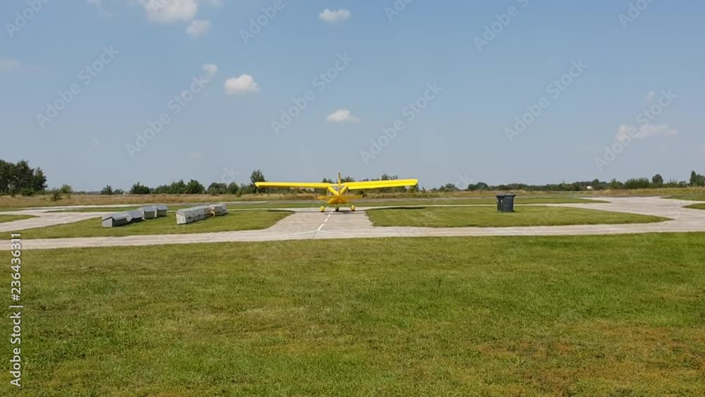 yellow plane with a propeller moves on the airfield preparing to take off yellow plane with a propeller moves on the airfield preparing to take off
