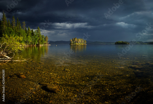 Stormy weater above the lake, small sunny island. photo