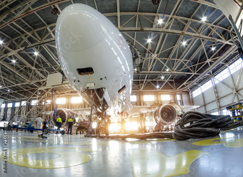 Airplane in the hangar for maintenance, bottom nose view.