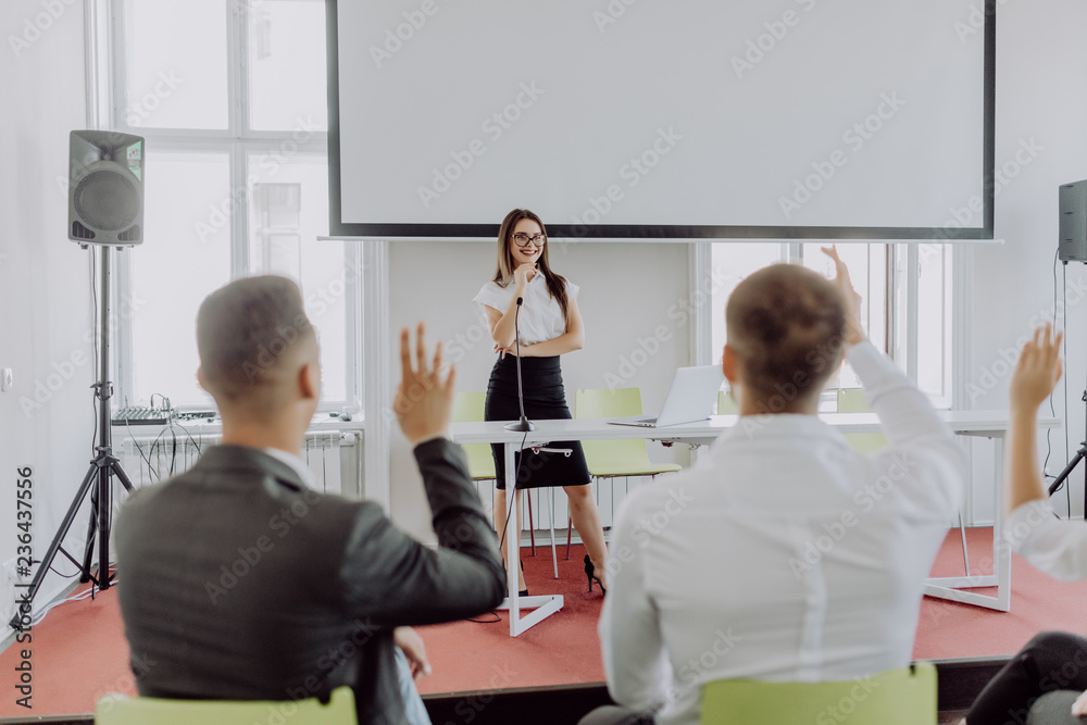 Colleagues asking a question to a businesswoman during a presentation. Business conference or training. Colleagues asking a question to a businesswoman during a presentation. Business conference or training.
