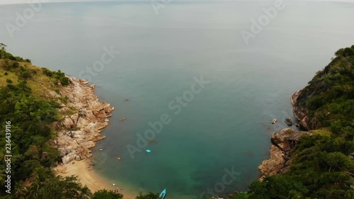 Aerial drone top view of white sand tropical exotic paradise tiny shore in Koh Prangan island, Thailand. Small boats on ocean surface. Cute remote beach with volcanic stones and green coconut palms. photo