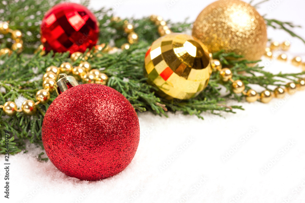 Christmas red and golden baubles and evergreen branches on white background. Place for text. Christmas red and golden baubles and evergreen branches on white background. Place for text.