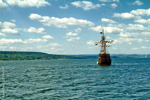 Pirate ship at the open sea at the sunset