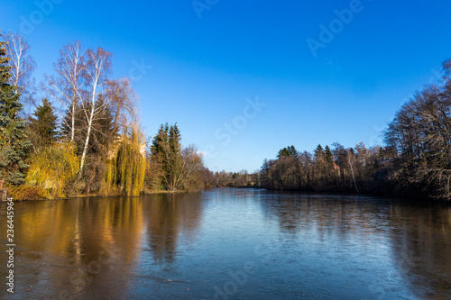 Partially frozen pond in winter. End of autumn. Austria.