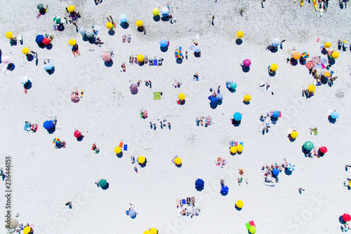 colorful vibrant umbrellas on a busy beautiful white sand beach
