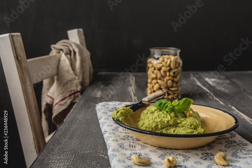 Avocado cashew spread with basil on plate, knife