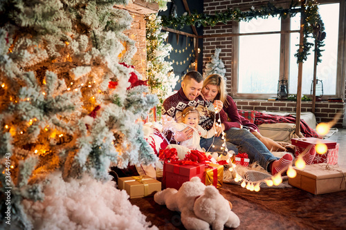 Happy family with a baby in a Christmas room. © Studio Romantic