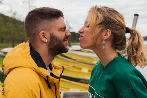 Finland, Lapland, funny young couple grimacing at the lakeside