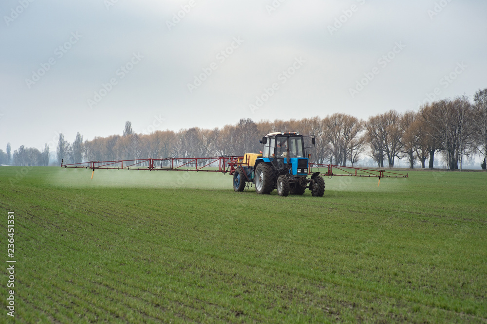farm tractor spraying agrochemical or agrichemical over young grain field in most cases agrichemical refers to pesticides like insecticides herbicides fungicides and nematicides farm tractor spraying agrochemical or agrichemical over young grain field in most cases agrichemical refers to pesticides like insecticides herbicides fungicides and nematicides