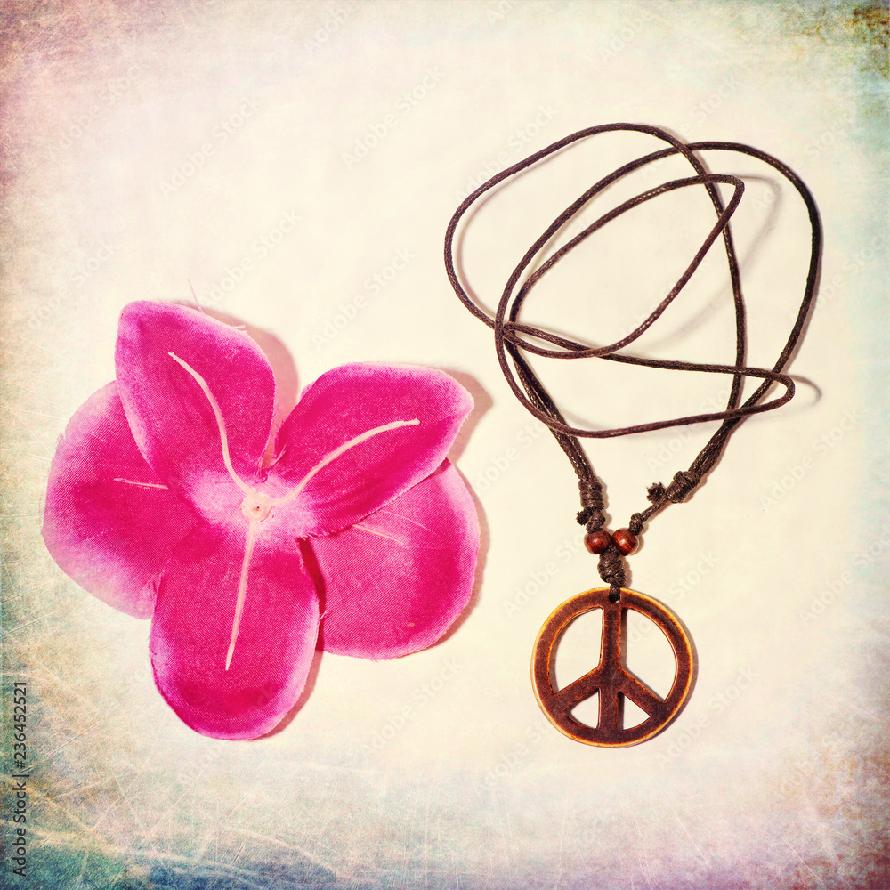 Symbol of peace next to a flower on colorful vintage background