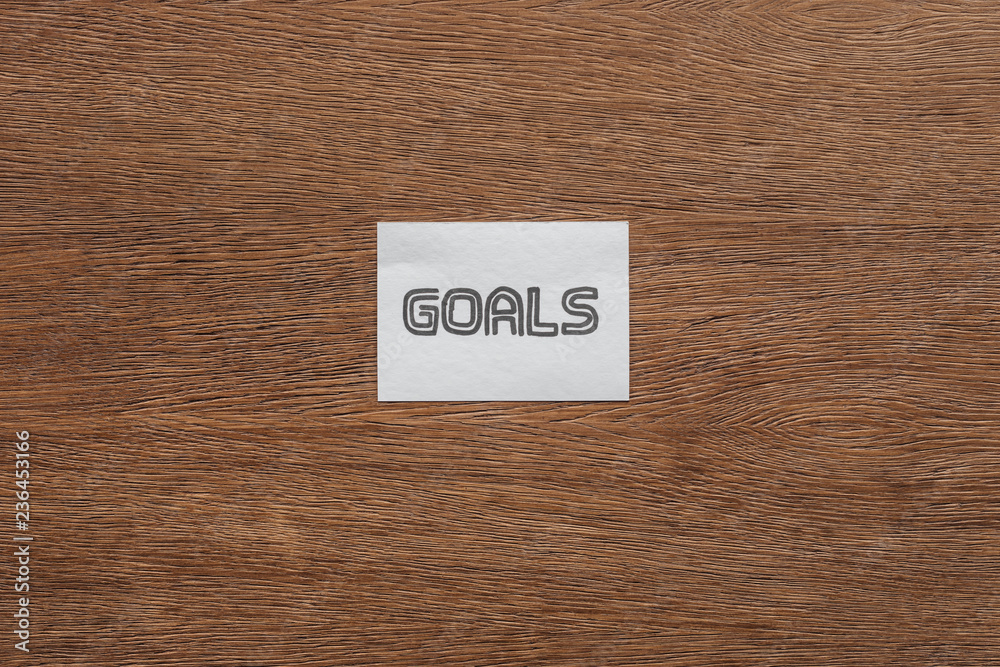 top view of 'goals' lettering on card with wooden background top view of 'goals' lettering on card with wooden background