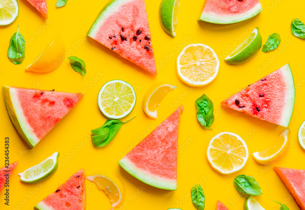 Above view at cutted lemons and limes with watermelon on yellow background Above view at cutted lemons and limes with watermelon on yellow background