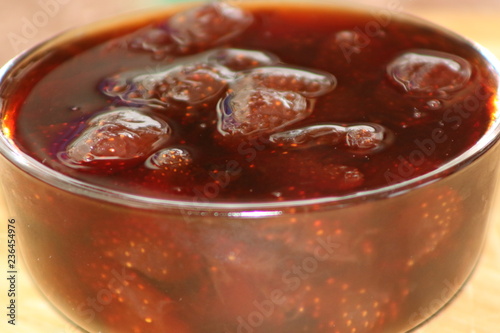Strawberry jam into glass bowl