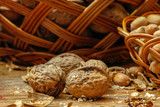 Walnuts and hazelnuts whole and cracked in old baskets.  Close-up, healthy food with rustic background