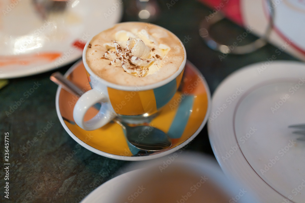 Cappuccino mit Sahne in einer bunten Tasse Cappuccino mit Sahne in einer bunten Tasse