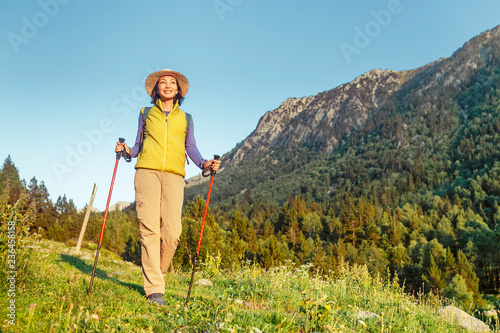 Young woman hiker camping near the beautiful shelter stone hut building in Pyrenees mountains. Hiking and adventure concept