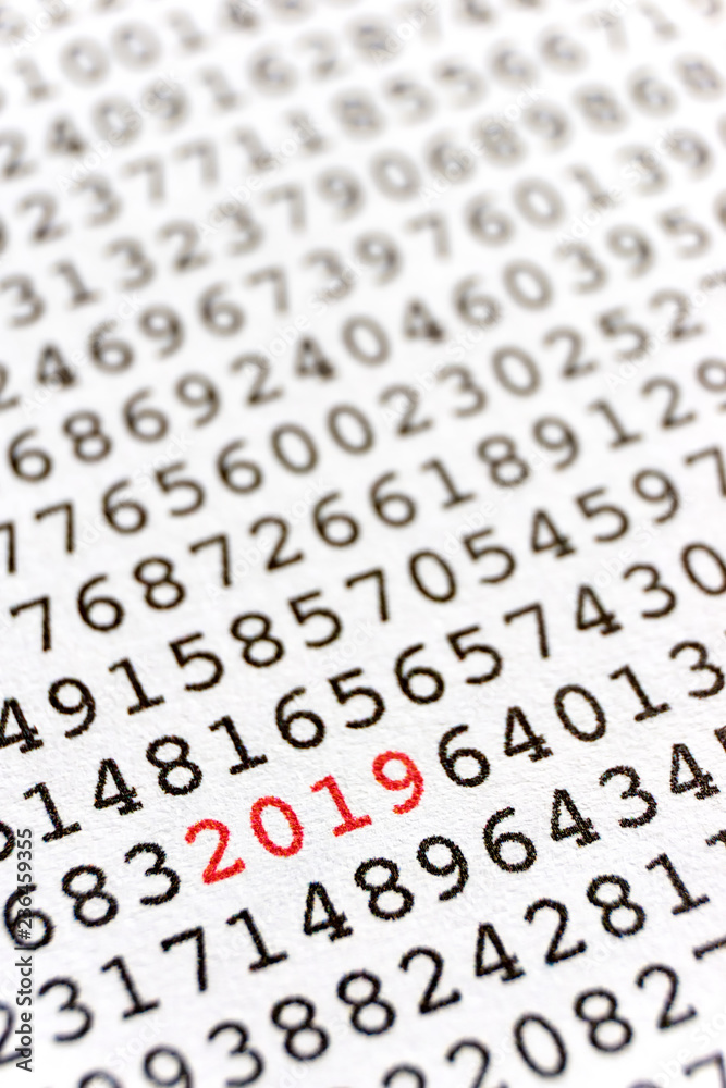 Background with black printed random numbers and the numbers 2019 in red for use as a template for a new year card or annual report. Vertical image. Background with black printed random numbers and the numbers 2019 in red for use as a template for a new year card or annual report. Vertical image.
