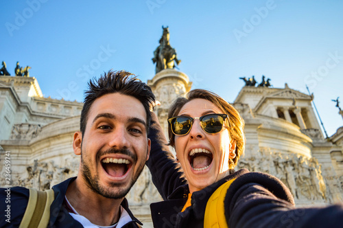 Happy travel couple taking selfie with the smartphone in famous landmark