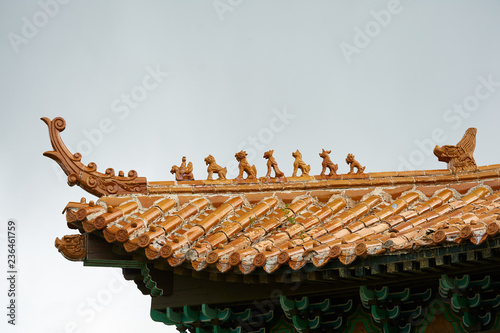 Detail of top orange tiled traditional rooftop in China, closeup view