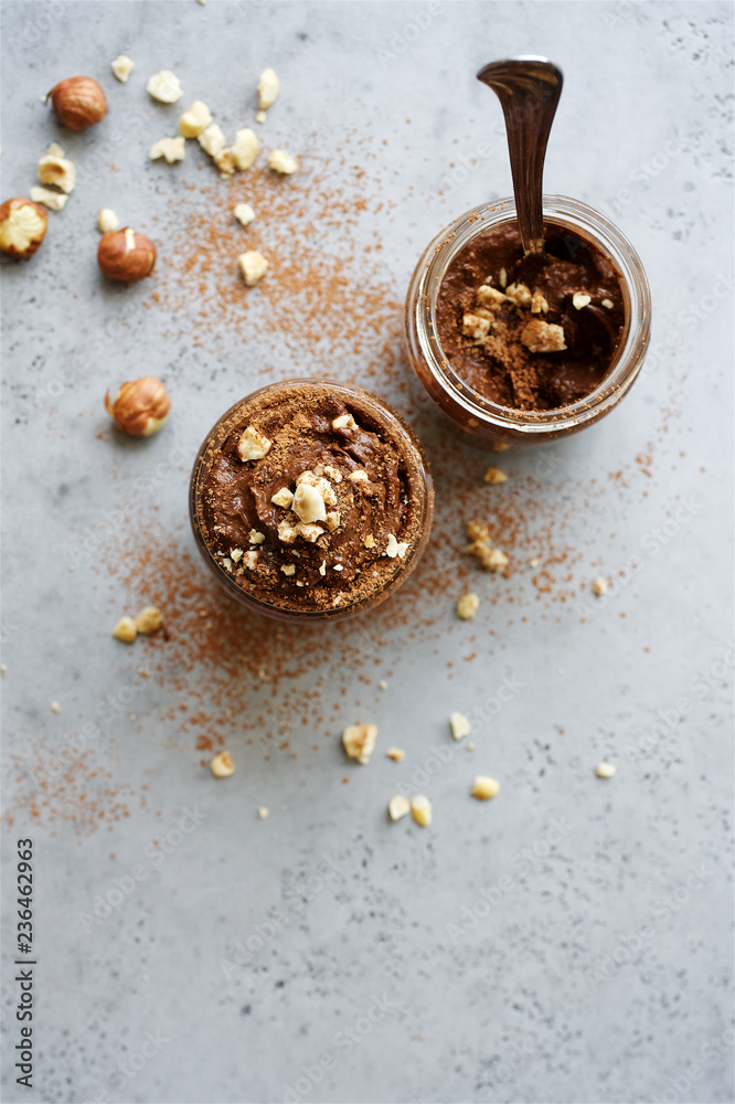 Chocolate mousse in glass jar. Avocado based healthy dessert. Gray concrete food background Chocolate mousse in glass jar. Avocado based healthy dessert. Gray concrete food background