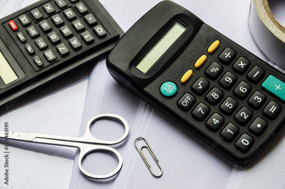 calculators and scissors on a white background calculators and scissors on a white background
