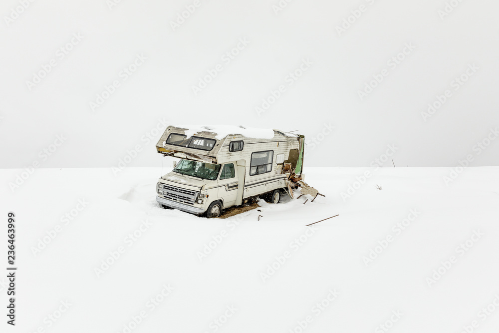 A wrecked RV, riddled with bullet holes, sits near a snowmobile trail, during a snow storm, Mohawk Valley, New York State, USA. A wrecked RV, riddled with bullet holes, sits near a snowmobile trail, during a snow storm, Mohawk Valley, New York State, USA.