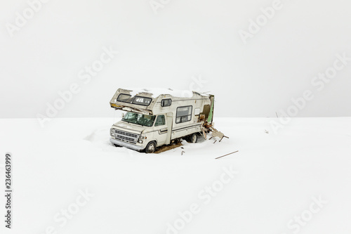 A wrecked RV, riddled with bullet holes, sits near a snowmobile trail, during a snow storm, Mohawk Valley, New York State, USA.