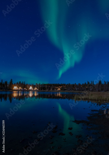 Magnificent grenish Northern light with refection in a lake at Yellow knife, Canada