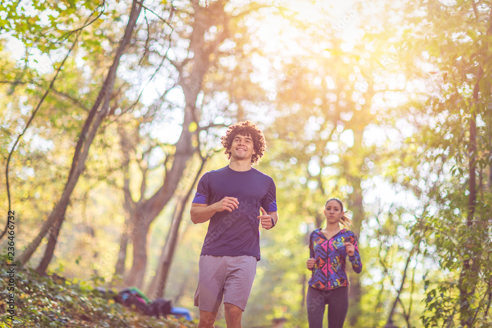 running is fun- Couple jogging and running outdoors in nature.