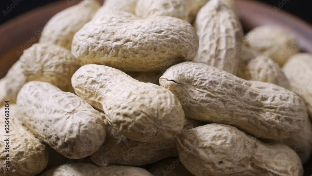 Unpeeled roast peanuts spinning - Top view, close up Unpeeled roast peanuts spinning - Top view, close up