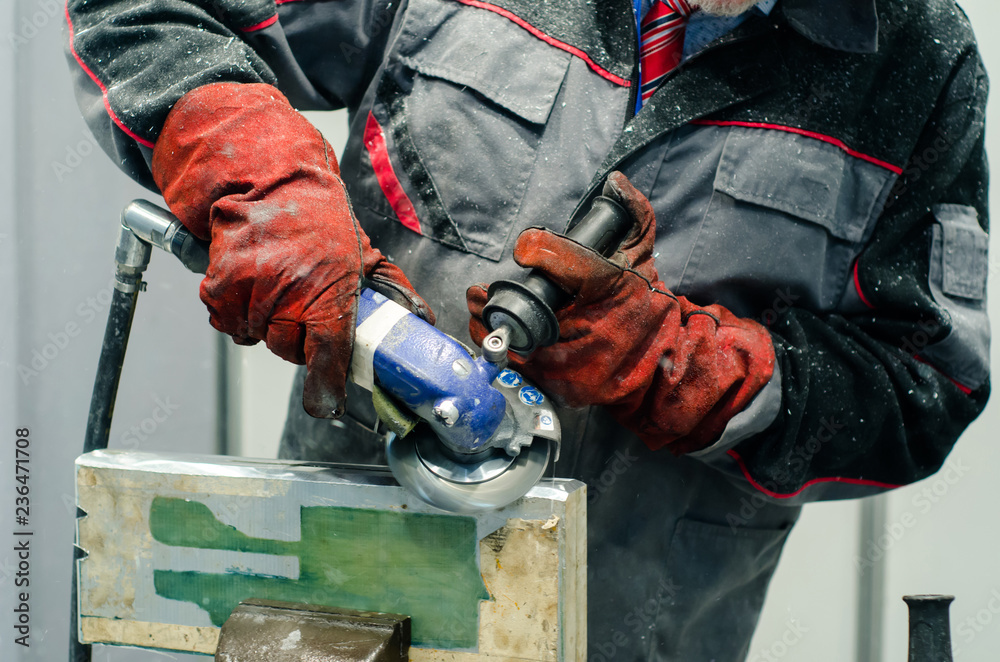 Worker using a grinder. Worker using a grinder.