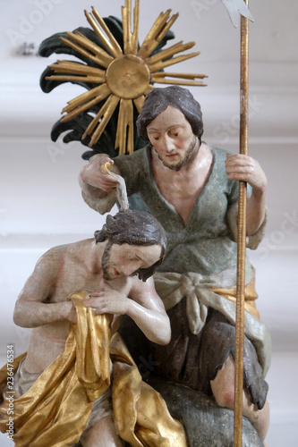 Baptism of the Lord, baptismal font in the Saint Martin church in Unteressendorf, Germany photo