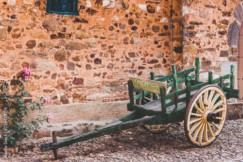 Empty bullock cart by the stone house in Castrillo de los Polvazares ancient village. Leon, Castilla Spain photo