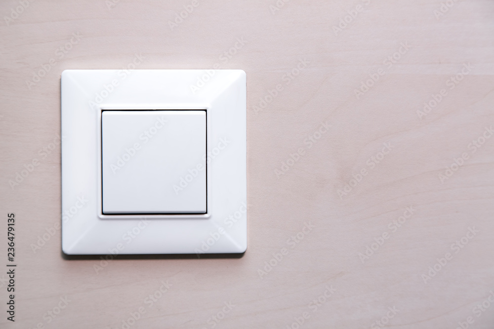 a light button switch on the wooden wall, a plastic mechanical switch close up. a light button switch on the wooden wall, a plastic mechanical switch close up.