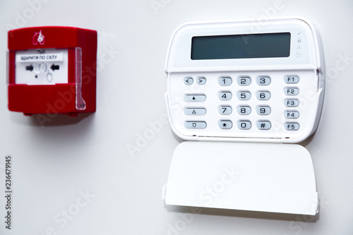 Tablou pe pânză alarm control panel and fire button on a light gray wall, close-up of the security password entry system to activate and set the alarm
