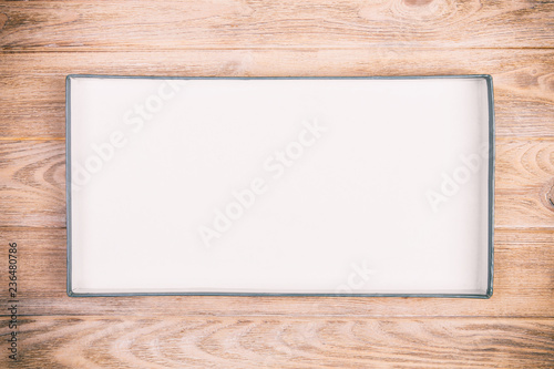 Opened cardboard box on wooden background. vintage, toned top view
