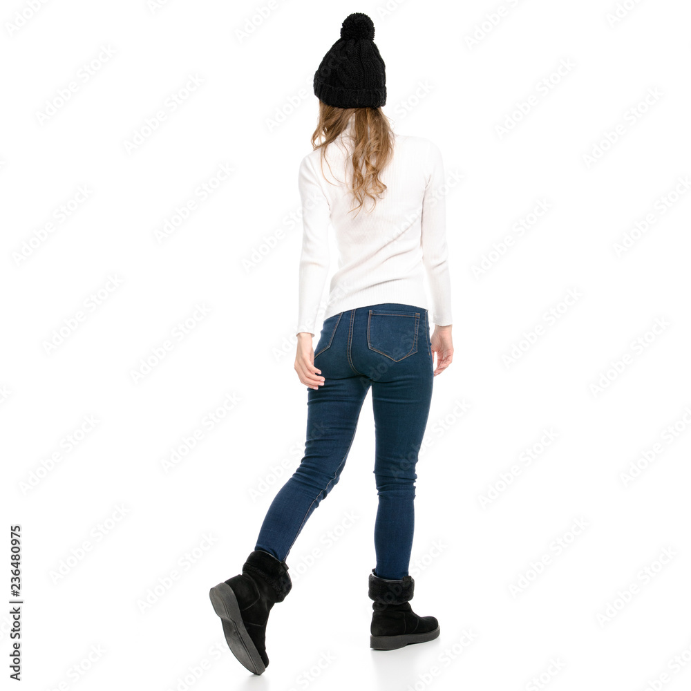 Beautiful woman in sweater jeans hat cold goes walking on white background isolation back view Beautiful woman in sweater jeans hat cold goes walking on white background isolation back view