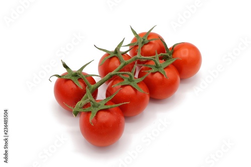 red cocktail tomatoes on vine isolated on white