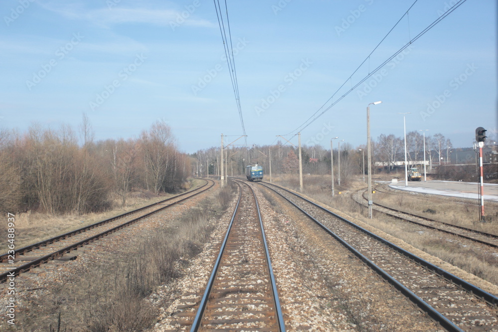 railroad, trucks and dry grass seen from the end of a train - wide angle photo in Poland, Europe