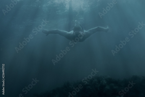 Active male freediver swimming underwater. © Alex Photo