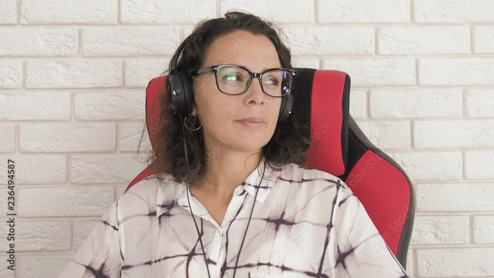Rest at work. A woman with glasses in headphones is resting at the workplace. Rest at work. A woman with glasses in headphones is resting at the workplace.